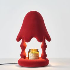 a red lamp with a jar on top of it