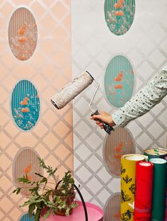 a person using a paint roller to decorate a wall