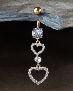 a pair of heart shaped danglings with clear stones on the end of each ear