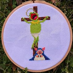 a cross stitched on to a piece of wood with an image of kermie from the muppet show