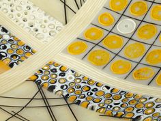 an art piece with yellow and white circles on it's surface, surrounded by black lines