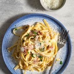 a plate of pasta with ham and parmesan cheese