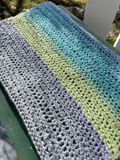 a crocheted blanket sitting on top of a green chair