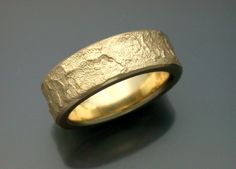 a gold wedding band that has been made to look like it is in the woods