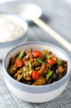 a bowl filled with meat and vegetables next to rice