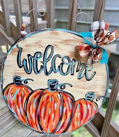 a welcome sign with pumpkins painted on it