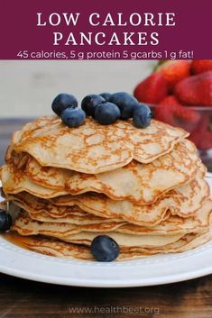 pancakes stacked on top of each other with blueberries and strawberries in the background