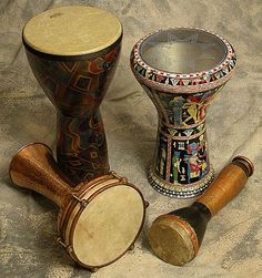 three different types of musical instruments sitting next to each other on a cloth covered surface