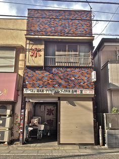 an apartment building with red and blue tiles on the side