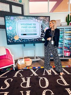 a woman is standing in front of a large screen with the words welcome to our store on it