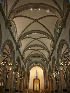 the inside of a church with high vaulted ceilings and stained glass windows on both sides