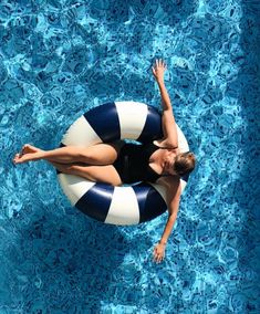 a woman in a black and white swimsuit floating on an inflatable raft