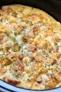 a casserole dish with ham, cheese and green onions in an crock pot