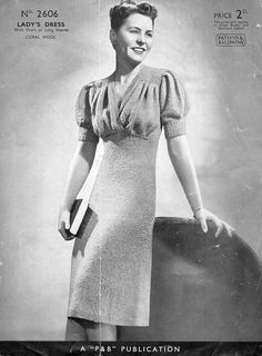 an old photo of a woman in a dress and hat with her hand on the back of a suitcase