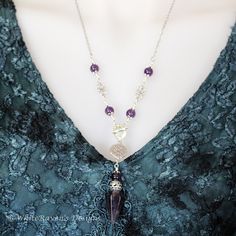 a woman wearing a necklace with amethorate beads and a purple bead