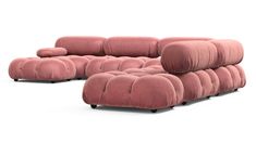 a pink couch sitting on top of a white floor next to a footstool