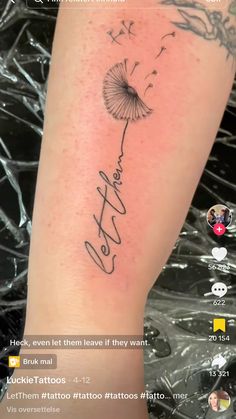 the back of a woman's leg with a dandelion tattoo on it