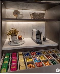 a shelf filled with lots of different types of chocolates and coffee cups on top of it