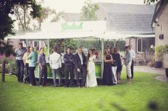 a group of people standing under a white tent