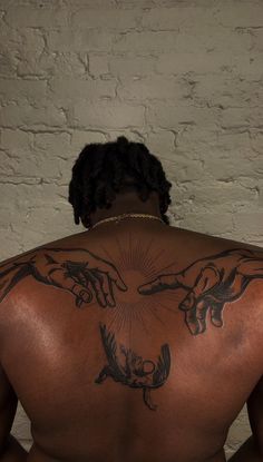 the back of a man with tattoos on his body