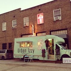 an ice cream truck is parked in front of a brick building with the door open