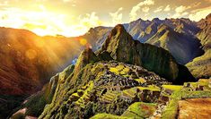 the sun is setting over machu pico, peru's ancient city and mountain range