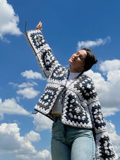 a woman is flying a kite in the sky with her hand up to the sky