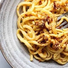 a fork in a bowl filled with pasta