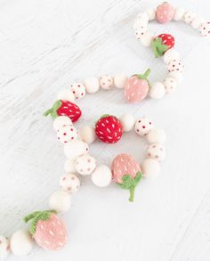 some white and pink beads with strawberries on them