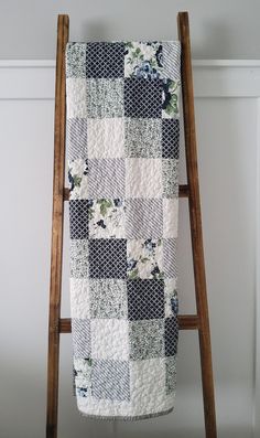 a quilt hanging on a wooden ladder