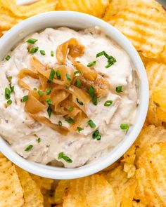 a white bowl filled with dip surrounded by chips