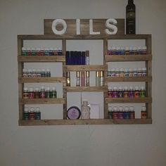 a shelf filled with lots of different types of bottles on top of wooden shelves next to a wall