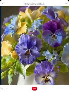 a vase filled with lots of purple and yellow flowers