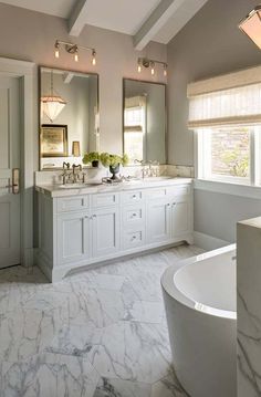 a bathroom with marble floors and white cabinets