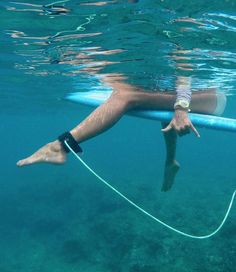 a man holding a surfboard in the water with his feet dangling off it's side