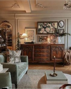 a living room filled with furniture and a chandelier above a table covered in candles