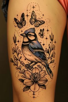 a woman's thigh with a blue bird and butterflies on the back of her leg