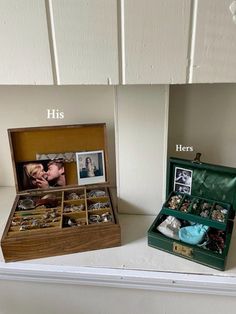 two boxes with pictures and jewelry on top of a white shelf next to each other