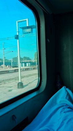 a view out the window of a train car looking at an empty bed and power lines