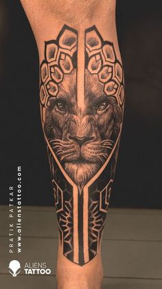 a man's leg with tattoos on it and a lion head in the middle