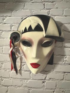 a white mask hanging on a brick wall