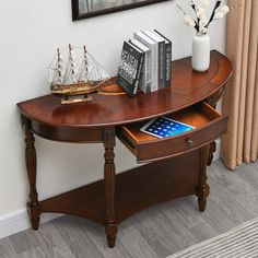 a wooden table with a tablet on it next to a vase filled with flowers and books