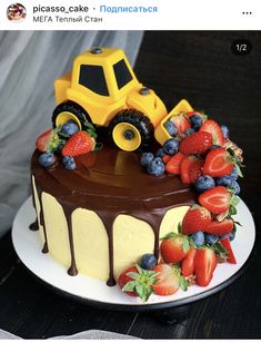 a cake with chocolate frosting and strawberries on the top is decorated like a tractor