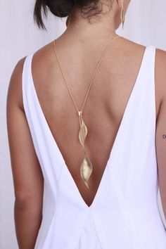 The perfect back necklace for your wedding dress or bridesmaids dresses. Leaf lariat necklace, long and perfect as a back necklace for backless dress. Features two winged leaf elements. The necklace fastens with a unique patented clasp which allows you to wear it in many ways and lengths.- Chain length: 31.5 inches (80 cm)- Leaves length 2-3 inches (5-7 cm)- Made of brass, plated with 24k gold, matte finished or rose gold- Available also in sterling Silver- Packed in a lovely gift box ready to g Luxury Elegant Backdrop Necklace With Clavicle Chain, Luxury Elegant Long Backdrop Necklace, Luxury Gold Backdrop Necklace With Clavicle Chain, Jewelry For Wide V Wedding Dress, Luxury Long Drop Backdrop Necklace For Women, Luxury Long Drop Backdrop Necklace, Luxury Evening Backdrop Necklace For Women, Luxury Gold Lariat Backdrop Necklace, Luxury Long Drop Backdrop Necklace As Gift