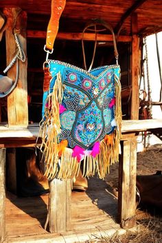 Add a touch of Ibiza magic to your outfit with this unique turquoise bohemian bag. Perfect for festivals, beach trips, and everyday adventures, this bag is designed to make every outfit stand out. Features: Unique Bohemian Turquoise Design: This beautiful embroidered boho bag is adorned with intricate bead trims and decorated with feathers, giving it a special Ibiza vibe. -Premium Materials: Made from blue-colored skin with gold-colored streaks on both the front and back, and trimmed with beauti