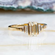 a three stone diamond ring sitting on top of a table