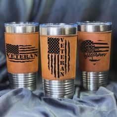 three leather cups with the words veteran and an american flag are sitting next to each other