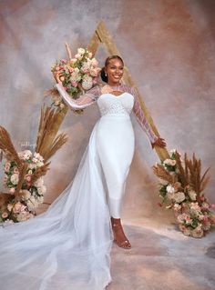 a woman in a white dress is posing for a photo