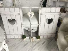 a white chair sitting inside of a room next to a wall with hearts on it