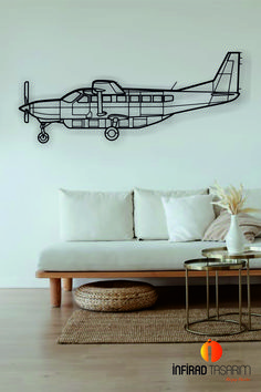 a living room with a white couch and a metal airplane on the wall above it